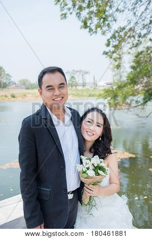Asian bride and groom happy in park