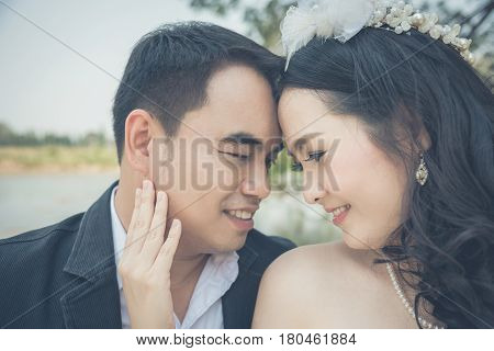 Asian bride and groom happy in park