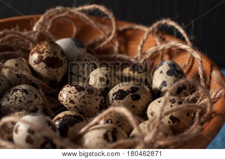 Quail Eggs In Wooden Bowl Isolated On Blue Background Close Up