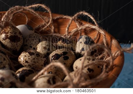 Quail Eggs In Wooden Bowl Isolated On Blue Background Close Up