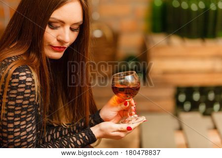 Woman Tasting Wine In Rural Cottage Interior