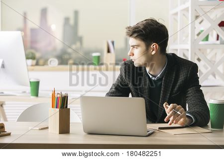 Portrait of handsome caucasian businessperson working on project at workplace. Work concept