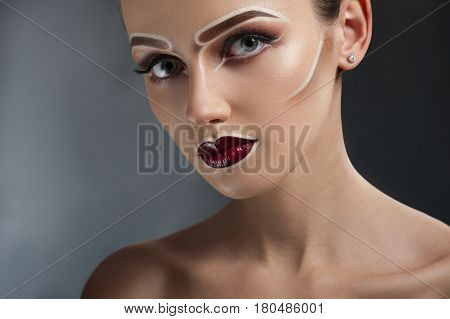 Hypnotizing depth. Closeup portrait of a gorgeous woman wearing artistic pop art makeup in brown tones