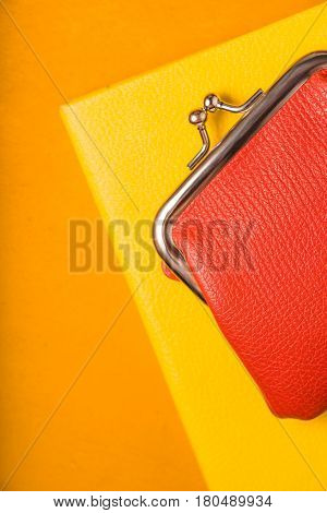 Orange wallet on a yellow notebook vertical
