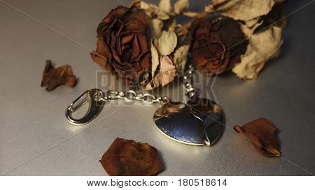 Red Roses and chromium jewelry Heart with grey background