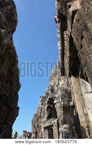 A narrow path between two ancient buildings. Detail of carvings in Angkor Wat UNESCO world heritage. Cambodia.