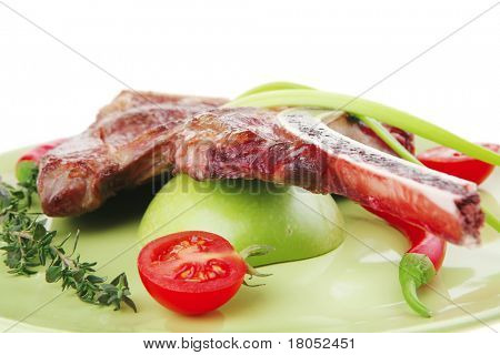 cibo di carne: manzo alla griglia di ricambio rib sul piatto verde con timo pepe e pomodoro isolato sopra ba bianco