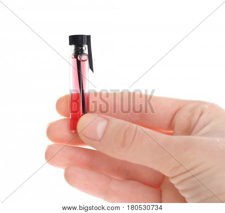 Female hand holding perfume sample on white background