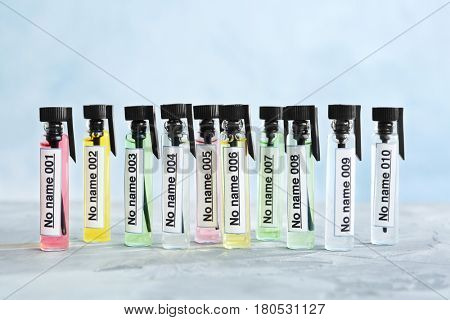Different perfume samples on light background