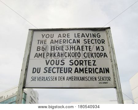 BERLIN, GERMANY - JULY 20, 2016: Famous historical  sign at former East West Berlin border. Former Checkpoint Charlie, old sign with warning of leaving the american sector during World War 2, Cold war