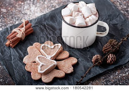 coffee mug with cookies and marshmallows cinnamon sticks and fir cones
