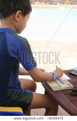 一个年轻的男孩专注于他的水彩作品