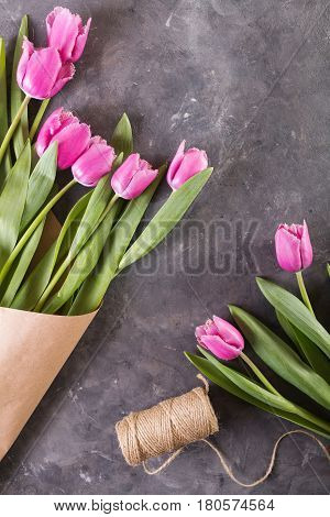 Pink tulips in a package of craft. Pink tulips on gray abstract background. Pink tulip. Tulips. Flowers. Flower background.. Pink tulip. Tulips. Flowers. Flower background. Flowers photo concept. Holidays photo concept. Copyspace