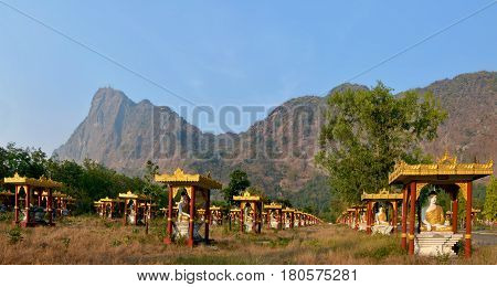 1000 Buddhas Garden At Sunset In Hpa-an, Myanmar. Mount Zwegabbin On The Background. Panoramic View.