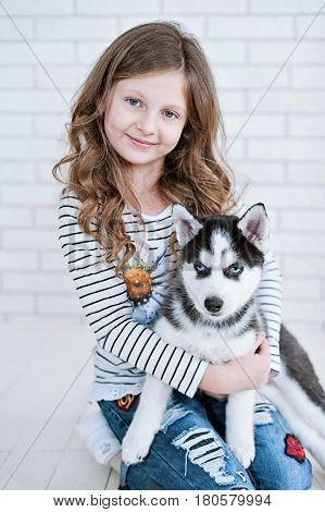 Little Girl Hugging A Puppy Husky