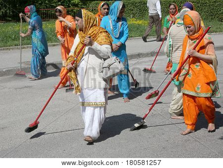 Vicenza, Vi, Italy - April 8, 2017: Barefoot Women Sikh Religious Sweeping The Street With Brooms Du