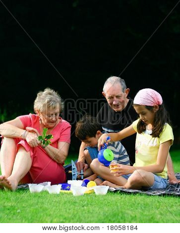 Grands-parents, profitant de l'été en plein air divertissant les petits-enfants.
