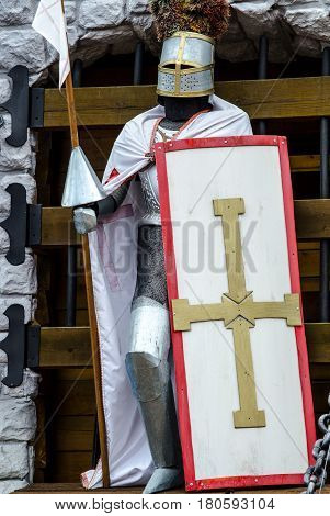Knight Crusader with shield and spear guards the gates of the castle