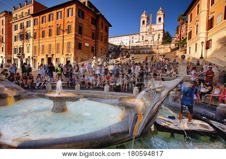 The Spanish Steps (Piazza di Spagna), Rome, Italy - July 11, 2012: Crowded with tourists. The Spanish Steps in Rome with fountain called Fontana della Barcaccia 