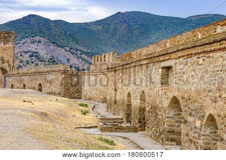 Walls of Genoese fortress in Sudak Crimea. Scenic views of rocky cliffs near ancient Genoese fortress on the background of cloudy sky