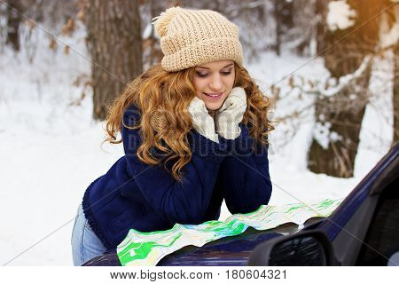 Beautiful Young Smiling Girl Looking In The Map On The Car Bonnet, Wearing Blue Jacket. Travel Girl.