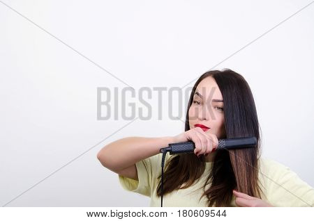 a woman with the rectifier of hair does a hair-do