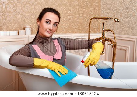 Female cleaning servisce worker sitting in bath