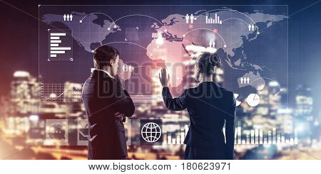 Two business people standing with back and working together with virtual screen