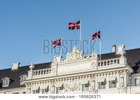 Flags flying in the wind on the Facade of the Hotel D´angleterre in Copenhagen Denmark - April 6 2017
