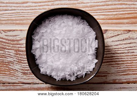 Maldon sea salt flakes in a bowl on a wooden board