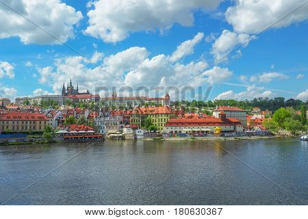 Prague cityscape with a view of Prague Castle and St Vitus Cathedral from Charles Bridge on a sunny summer day.