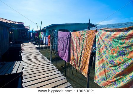 Passerella in legno con la linea di lavaggio colorato nel villaggio di acqua vicino Tuaran, Sabah Malaysia