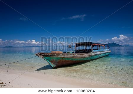 จอดเรือไม้โดด ๆ บนเกาะเขตร้อนน้ำใส