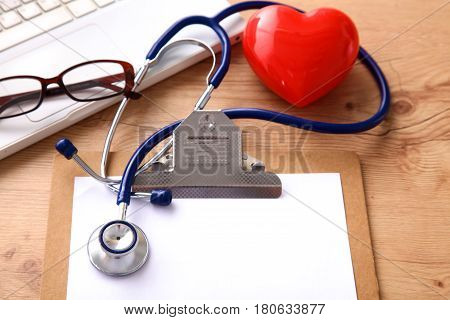 A medical stethoscope lies on the patient's medical history on a computer background. The concept of medical care or insurance.