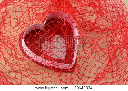 Falling in love or red and white heart captured in red net for Valentine's Day