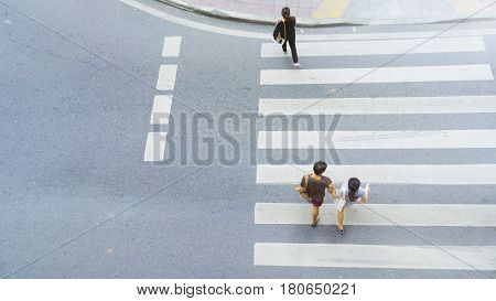 Top view of city people are walking across crosswalk in the city street.