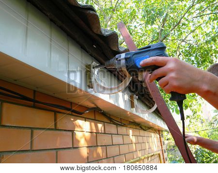 Holder gutter drainage system on the roof. Rain Gutter Holder Installation