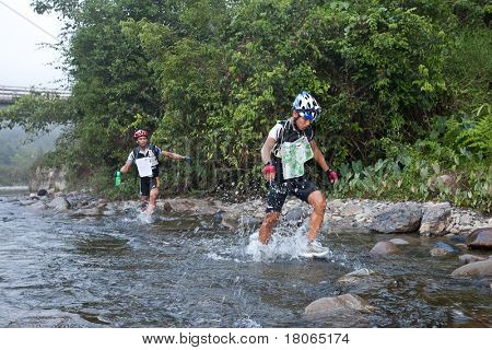 SABAH, MALEISIË - 2 APRIL.  Een racer uit een deelnemende team maakt zijn weg in een rivier in de 