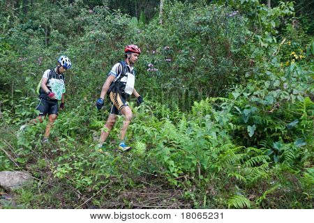 SABAH, MALEISIË - 2 APRIL. Een racer uit een deelnemende team maakt hun weg langs en over een ri