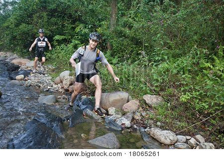 SABAH, MALEISIË - 2 APRIL. Een racer uit een deelnemende team maakt hun weg langs en over een ri