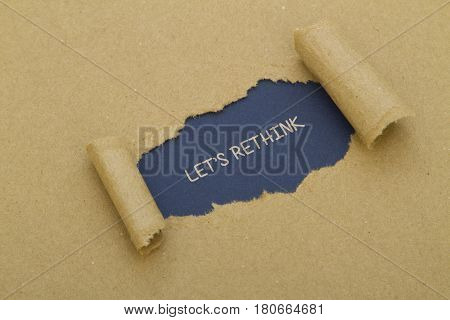 LET'S RETHINK word written under torn paper.