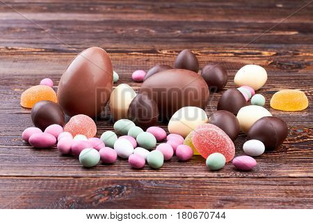 Sweets on brown wood. Chocolate eggs and jellies. Blood sugar control tips.
