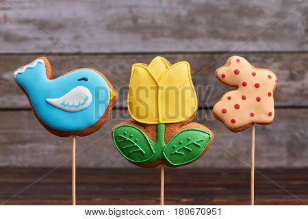Three Easter biscuits on sticks. Cookies with colorful glaze. Easter classroom treat ideas.