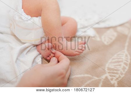 family, motherhood, parenting, people and child care concept - close up of newborn baby feet in mother hands