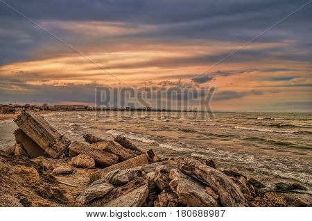 Sunset At The Sea Shore Of A Beach With Rocks And Stormy Waves, Beautiful Seascape At Caspian Sea Ab
