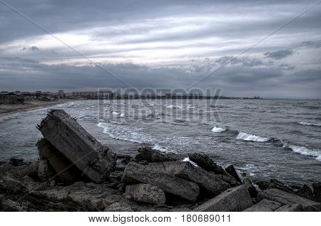 Sunset At The Sea Shore Of A Beach With Rocks And Stormy Waves, Beautiful Seascape At Caspian Sea Ab