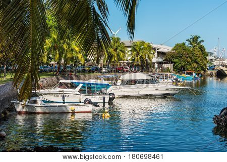 Victoria Mahe Seychelles - December 16 2015: Boats resting at the colourful palm-lined Victoria Harbour in Mahe Island Seychelles Indian Ocean Africa.
