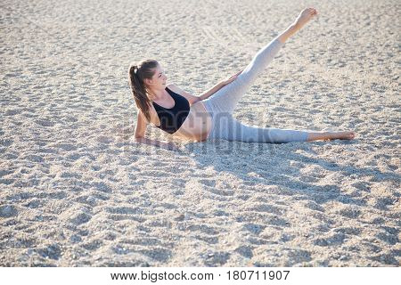 beautiful girl engaged in fitness Yoga on the beach