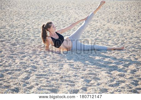 beautiful girl engaged in fitness Yoga on the beach