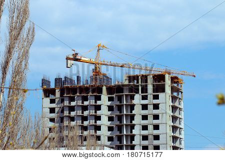 High crane on the construction of a multifamily urban residential building